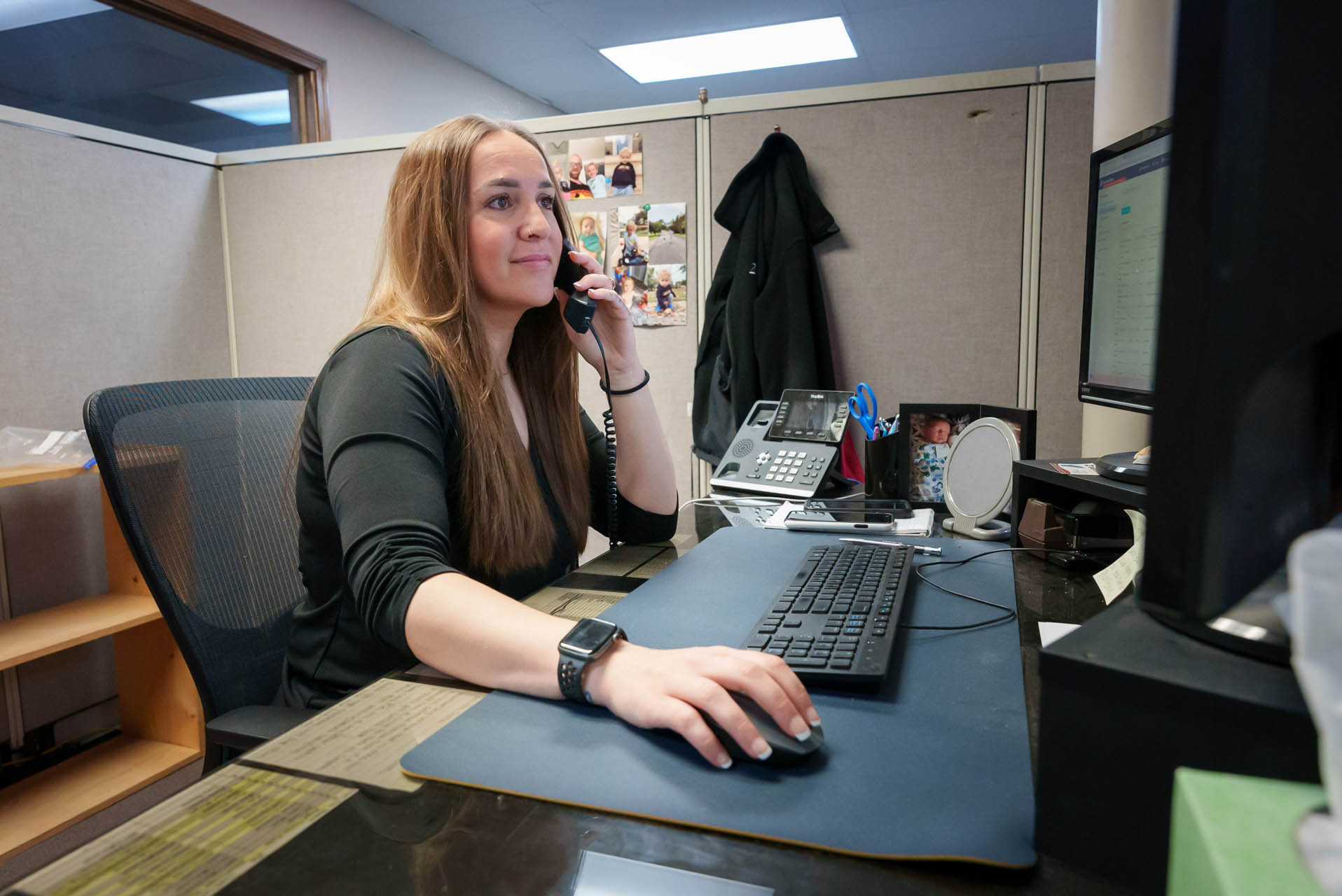 A 2nd Wind Heating and Air Conditioning employee working on a computer while on the telephone in Columbia, SC